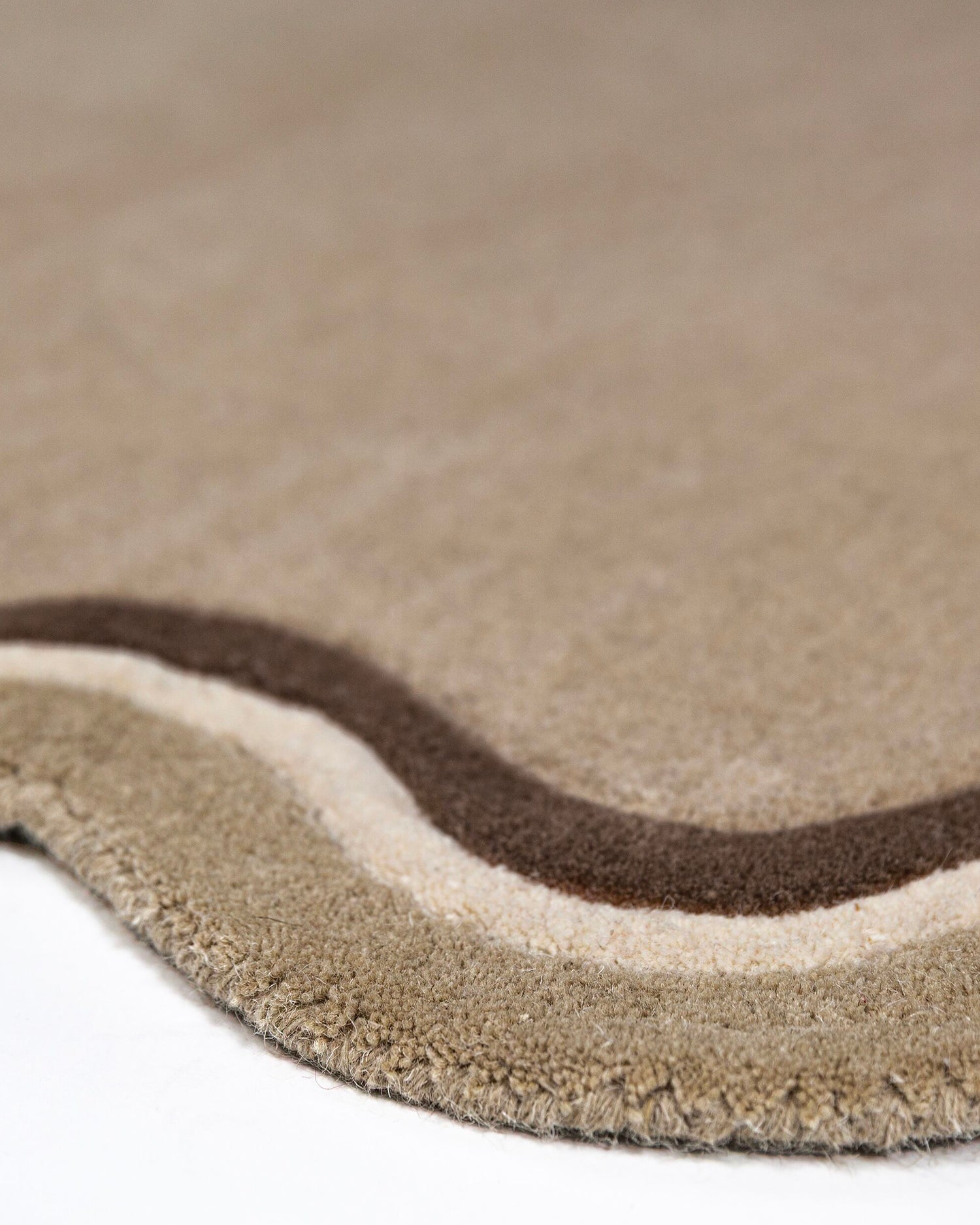 Tappeto rotondo in lana con bordo smerlato Leo
