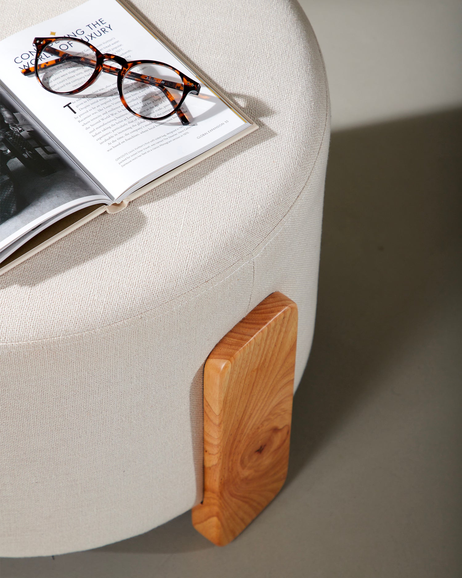 Pouf imbottito in lino con piedini in legno Coffey