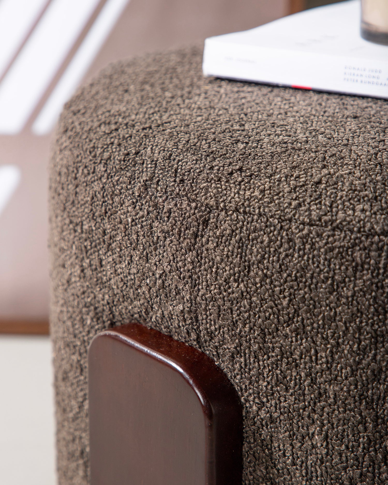 Pouf imbottito in bouclè con piedini in legno Coffey