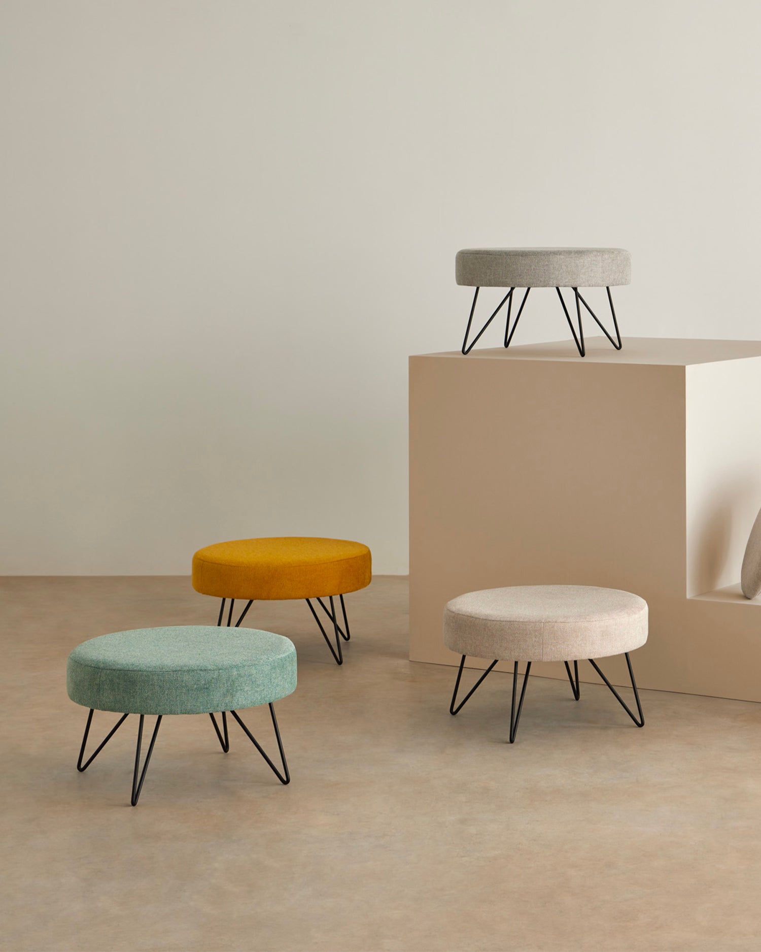 Pouf rotondo imbottito con gambe in metallo Aron