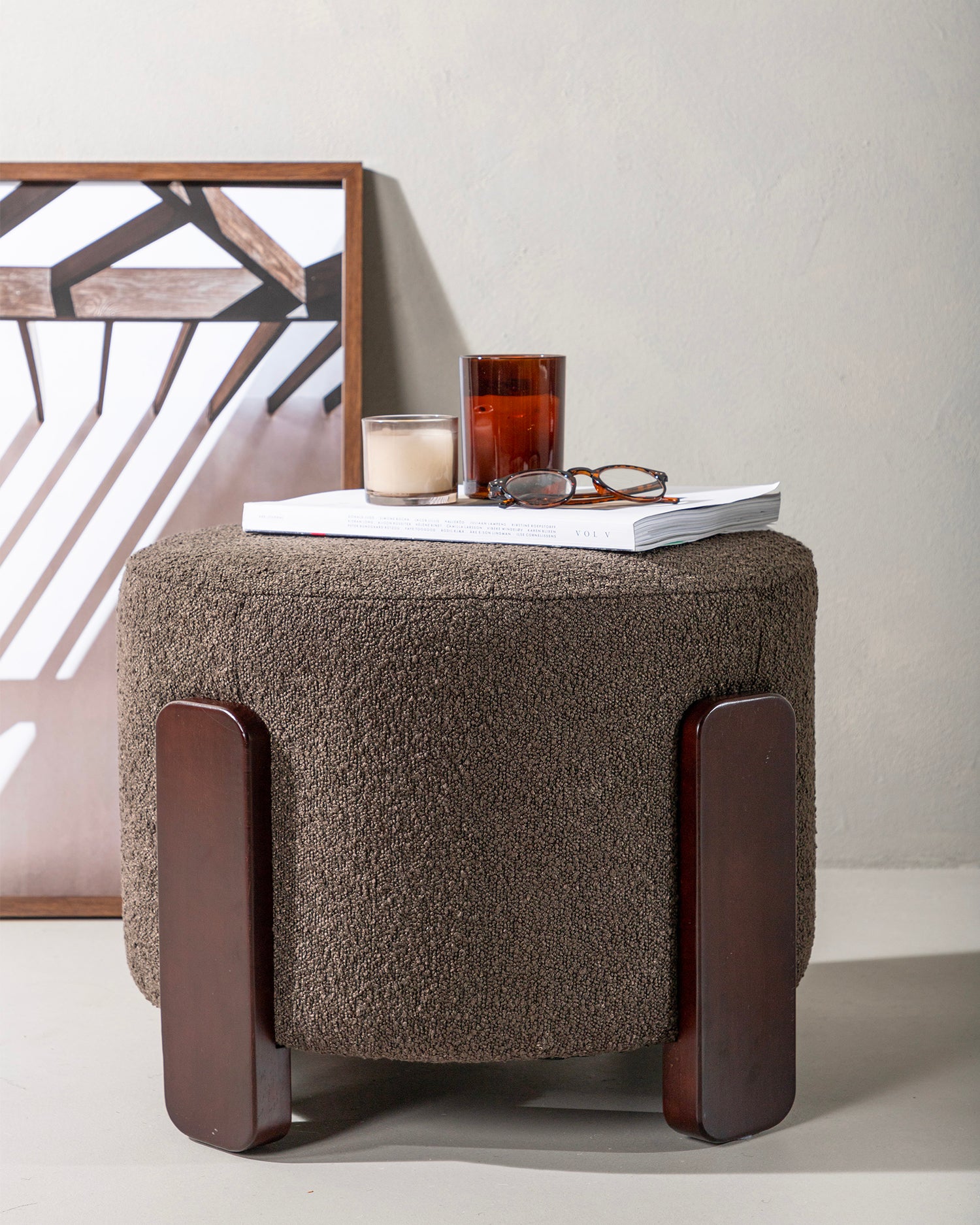 Pouf imbottito in bouclè con piedini in legno Coffey